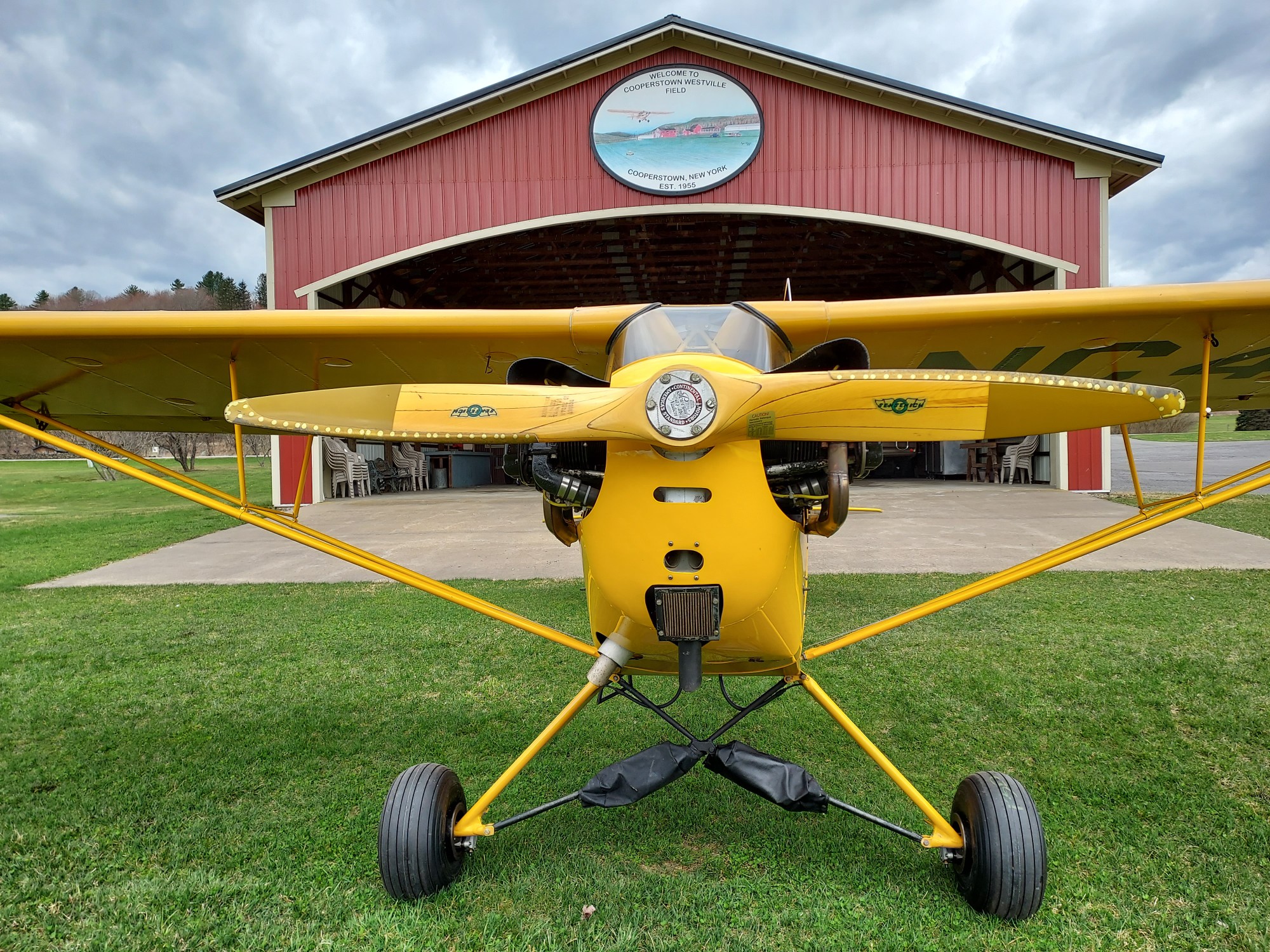 Yellow Piper Cub in front of the main hangar