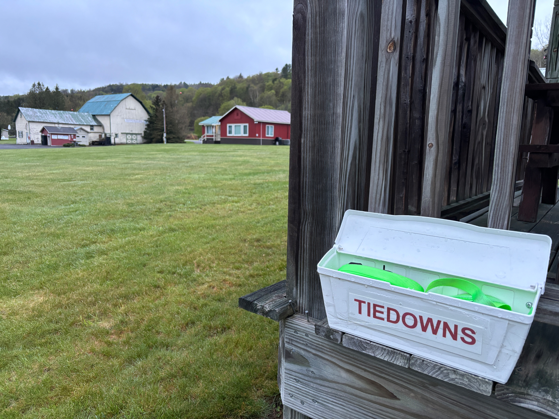 Tiedown straps box on porch with hangars and green field