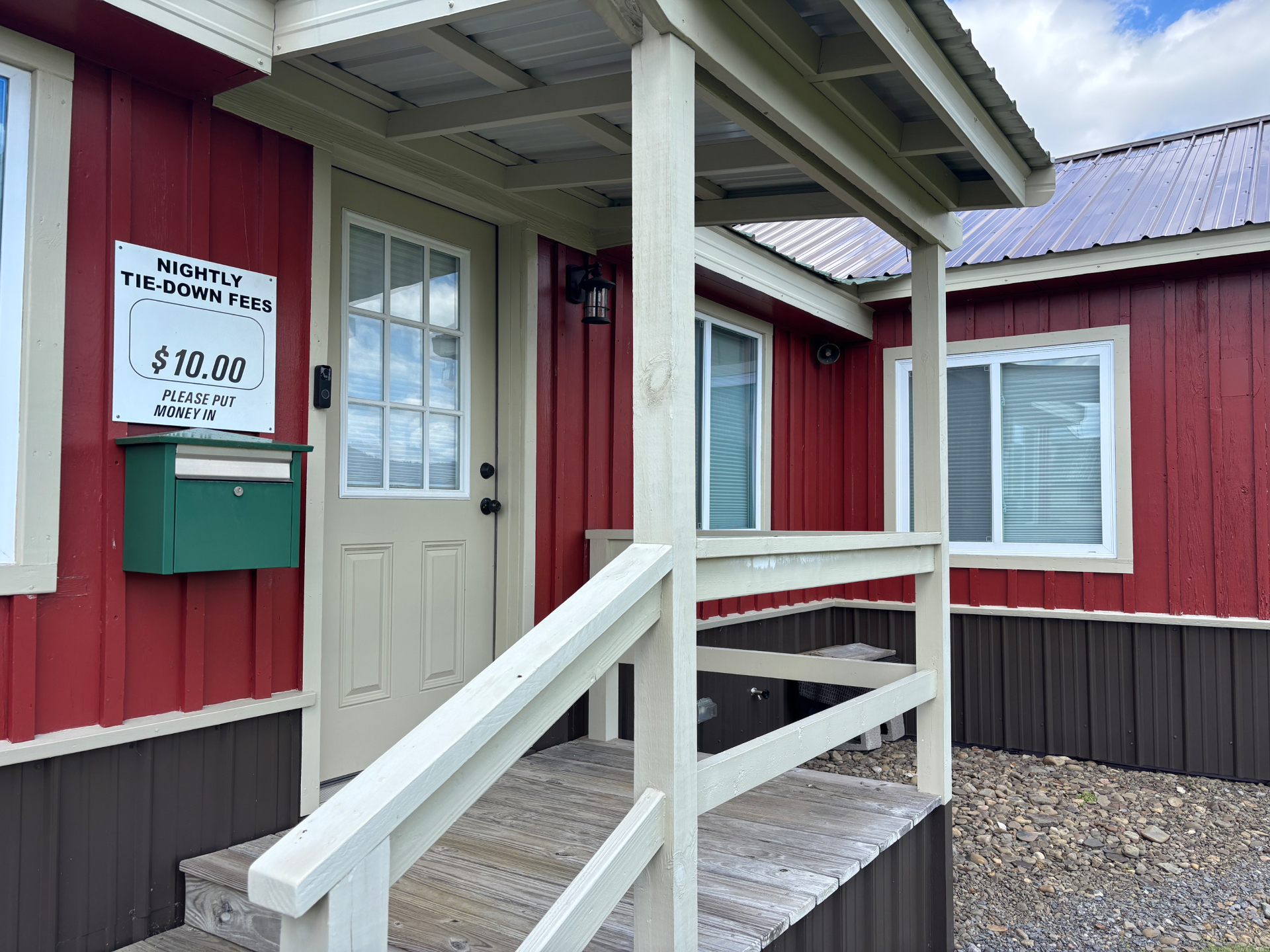 Airport office entrance with tie-down fee sign and covered porch