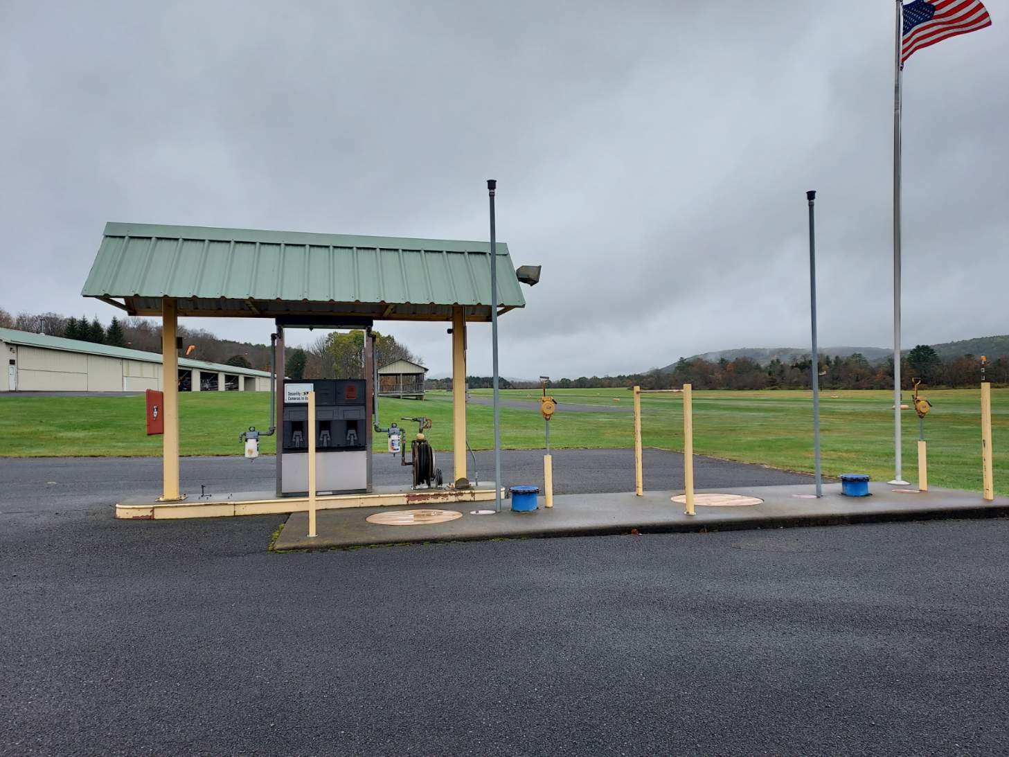 Fuel station with American flag and grass runway beyond